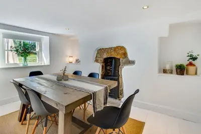a dining room with a table and chairs and a fireplace at 2 Bed in Breage oc-jobcot in Breage