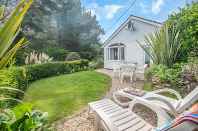 a garden with a white bench and a table at 2 Bed in Looe oc-l00055 in Trelaske