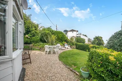 a patio with a table and chairs in a yard at 2 Bed in Looe oc-l00055 in Trelaske