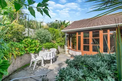 a patio with a table and chairs in a garden at 1 Bed in Looe oc-l00063 in Trelaske