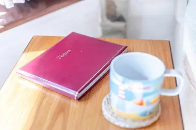 a book on a table next to a coffee mug at 1 Bed in Looe oc-l00063 in Trelaske