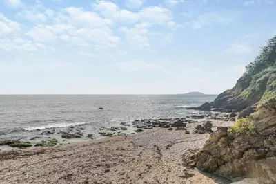 a beach with a rocky shore and the ocean at 1 Bed in Looe oc-l00063 in Trelaske