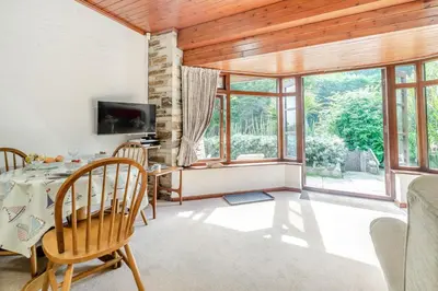 a dining room with a table and chairs and windows at 1 Bed in Looe oc-l00063 in Trelaske