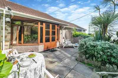 a patio with a table and chairs in front of a house at 1 Bed in Looe oc-l00063 in Trelaske
