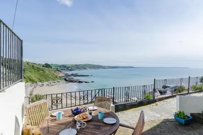 a wooden table on a balcony with a view of the ocean at 2 Bed in Looe oc-l10082 in Looe