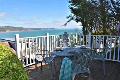 a table and chairs on a deck with a view of the ocean at 2 Bed in Looe oc-l10082 in Looe