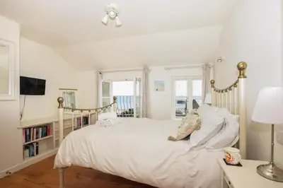 a white bedroom with a large bed and a tv at 3 Bed in Looe oc-l10098 in Looe