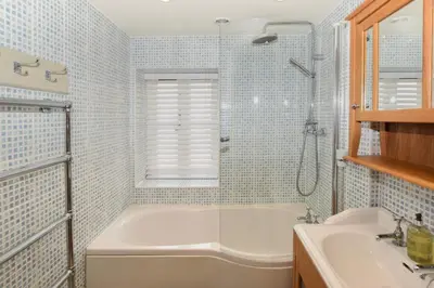 a bathroom with a tub and a shower and a sink at 3 Bed in Looe oc-l10098 in Looe