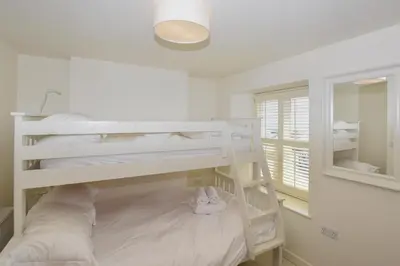 a bedroom with two bunk beds and a mirror at 3 Bed in Looe oc-l10098 in Looe