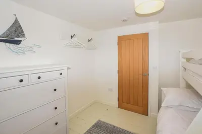 a bedroom with a bed and a wooden door at 3 Bed in Looe oc-l10098 in Looe