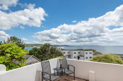 a balcony with two chairs and a table at 3 Bed in Looe oc-l30005 in Looe