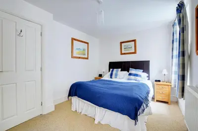 a bedroom with a blue bed in a white room at 1 Bed in Looe oc-l30006 in Looe
