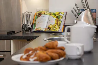 a plate of food on a counter with a book and a plate of food at 1 Bed in Looe oc-l30008 in Looe