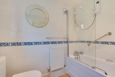a bathroom with a tub and a toilet and a mirror at 1 Bed in Looe oc-l30008 in Looe