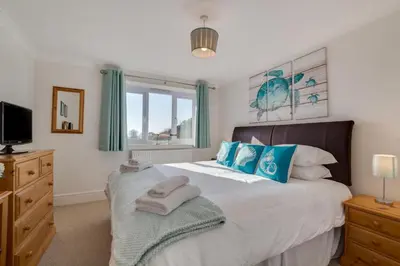a bedroom with a large bed with blue pillows at 1 Bed in Looe oc-l30008 in Looe