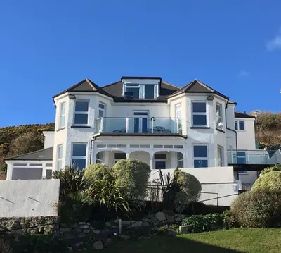 a white house with a balcony on top of it at 1 Bed in Looe oc-l30008 in Looe