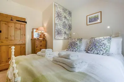 a bedroom with a white bed with towels on it at 2 Bed in Looe oc-l30015 in Lansallos