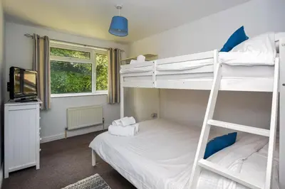 a bedroom with two bunk beds and a television at 2 Bed in Looe oc-l30020 in Looe