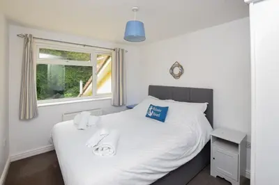 a bedroom with a white bed with towels on it at 2 Bed in Looe oc-l30020 in Looe