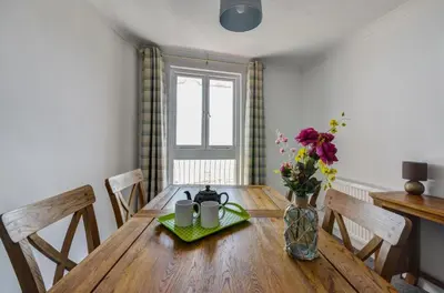 a dining room table with a vase of flowers on it at 2 Bed in Looe oc-l30035 in Looe