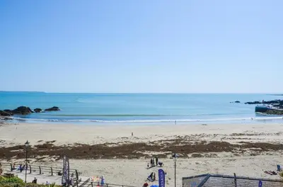 a beach with people on the sand and the ocean at 2 Bed in Looe oc-l30035 in Looe
