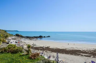 a beach with people on the sand and the ocean at 2 Bed in Looe oc-l30035 in Looe