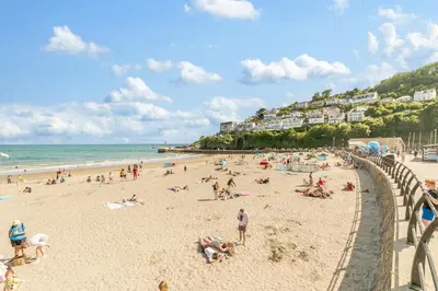 a group of people on a beach near the ocean at 1 Bed in Looe oc-l30038 in Looe