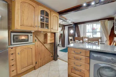 a kitchen with wooden cabinets and a dishwasher at 4 Bed in Looe oc-l30047 in Looe