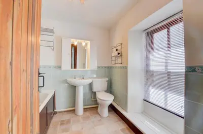 a bathroom with a toilet and a sink and a tub at 4 Bed in Looe oc-l30047 in Looe
