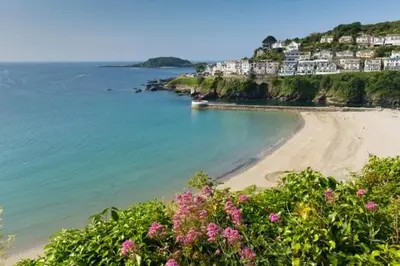 a view of a beach with pink flowers and houses at 4 Bed in Looe oc-l30047 in Looe