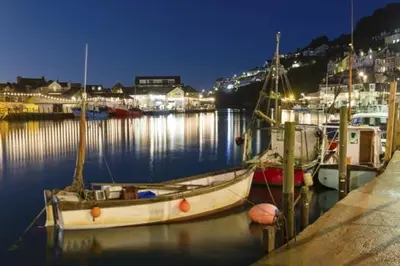 a group of boats docked in a harbor at night at 4 Bed in Looe oc-l30051 in Looe