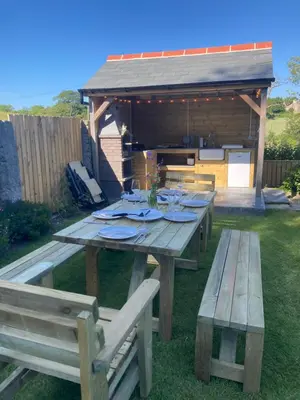 a picnic table in a yard with two benches at The parlour in Bodmin
