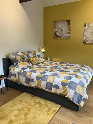 a bedroom with a bed with a blue and yellow comforter at The parlour in Bodmin