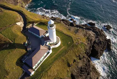 an aerial view of a lighthouse on a cliff at Brook Cottage Cornwall in St Merryn