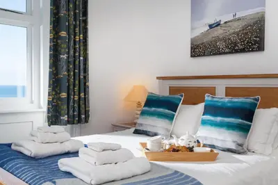 a bedroom with a bed with towels on it at Brook Cottage Cornwall in St Merryn