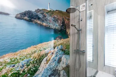 a shower with a view of the ocean at Brook Cottage Cornwall in St Merryn