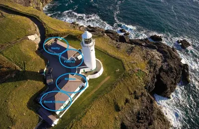 an aerial view of a lighthouse on the coast at Brook Cottage Cornwall in St Merryn