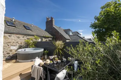 a garden with a table and a bath tub at Azenor House - Central Location - Hot Tub - Free Parking & WiFi - 3 Pets Accepted in St Ives