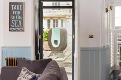 a living room with a couch in front of a door at Azenor House - Central Location - Hot Tub - Free Parking & WiFi - 3 Pets Accepted in St Ives