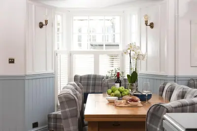 a dining room table with a bowl of fruit on it at Azenor House - Central Location - Hot Tub - Free Parking & WiFi - 3 Pets Accepted in St Ives