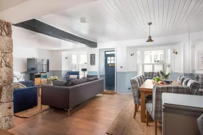 a living room with a couch and a table at Azenor House - Central Location - Hot Tub - Free Parking & WiFi - 3 Pets Accepted in St Ives