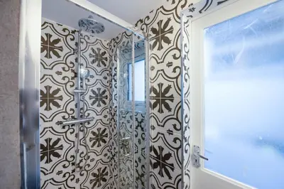 a bathroom with a shower with black and white tiles at Azenor House - Central Location - Hot Tub - Free Parking & WiFi - 3 Pets Accepted in St Ives