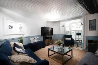 a living room with a blue couch and a tv at Azenor House - Central Location - Hot Tub - Free Parking & WiFi - 3 Pets Accepted in St Ives
