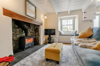 a living room with a stone fireplace and a couch at 1 Bed in Marazion oc-lynwo in Marazion
