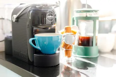 a coffee maker with a blue cup on a counter at 1 Bed in Marazion oc-lynwo in Marazion