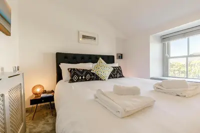a bedroom with a large white bed with a window at 1 Bed in Marazion oc-lynwo in Marazion