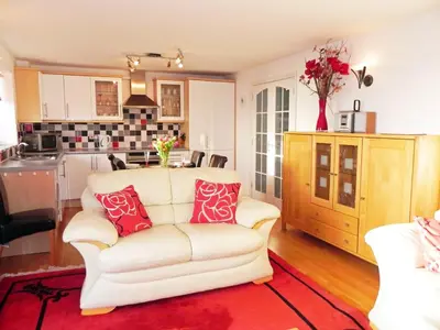 a living room with a white couch and a kitchen at 3 Bed in Porthleven oc-lamorn in Porthleven