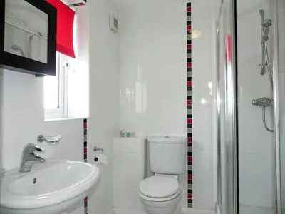 a white bathroom with a toilet and a sink at 3 Bed in Porthleven oc-lamorn in Porthleven
