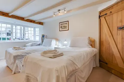 two beds in a bedroom with white walls and a window at 3 Bed in Fowey oc-litin in Fowey