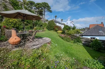 a garden with a table and an umbrella at 3 Bed in Fowey oc-litin in Fowey